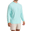 Close-up of a man wearing the Marsh Hoodie in aqua color with cream white color pants, cropped from chin to knees, against a solid white background.