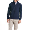 Close-up of a man wearingThe Traveler Jacket in Beaufain Blue with white pants, cropped from chin to knees, against a solid white background.