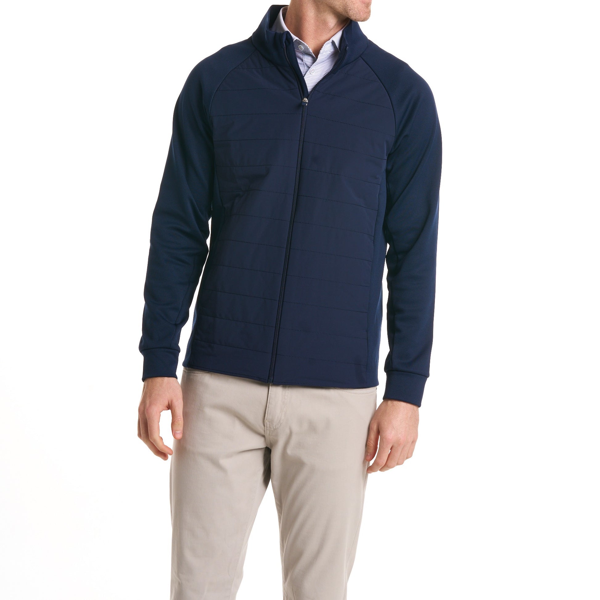Close-up of a man wearingThe Traveler Jacket in Beaufain Blue with white pants, cropped from chin to knees, against a solid white background.