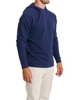 Close-up of a man wearing the Horizon Hoodie in Beaufain Blue with white pants, cropped from chin to knees, against a solid white background.