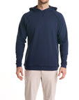 Close-up of a man wearing the Surfside  Hoodie in beaufain blue color with cream white color pants, cropped from chin to knees, against a solid white background.