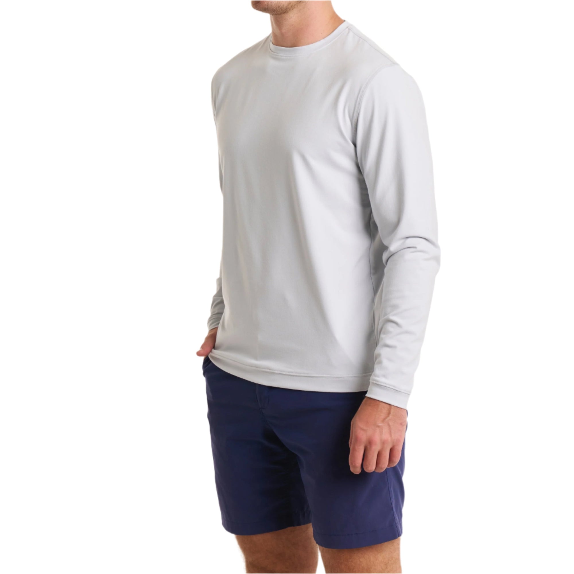 Close-up of a man wearing The Surfside Longsleeve Tee in Gaillard Gray with cream white color pants, cropped from chin to knees, against a solid white background.