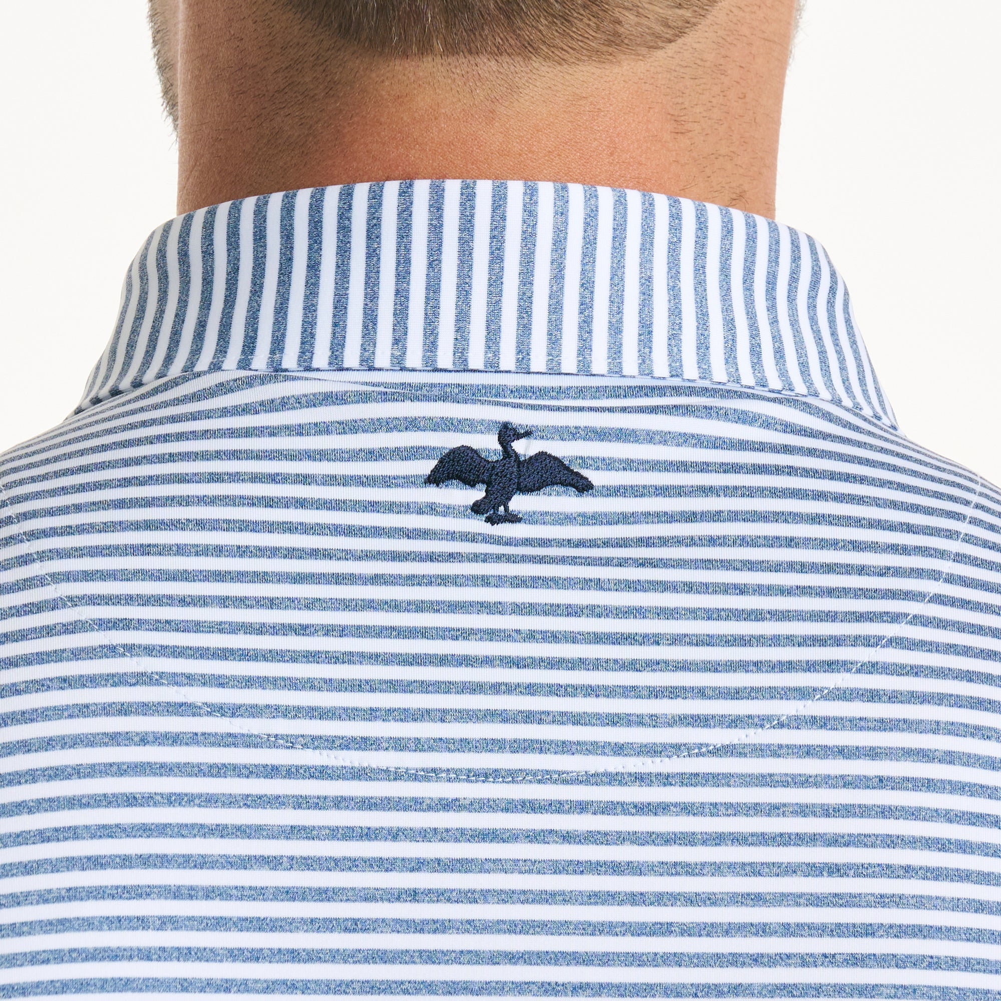 Close-up of the backside of a Harlestons's shirt collar exhibiting the cormorant logo.