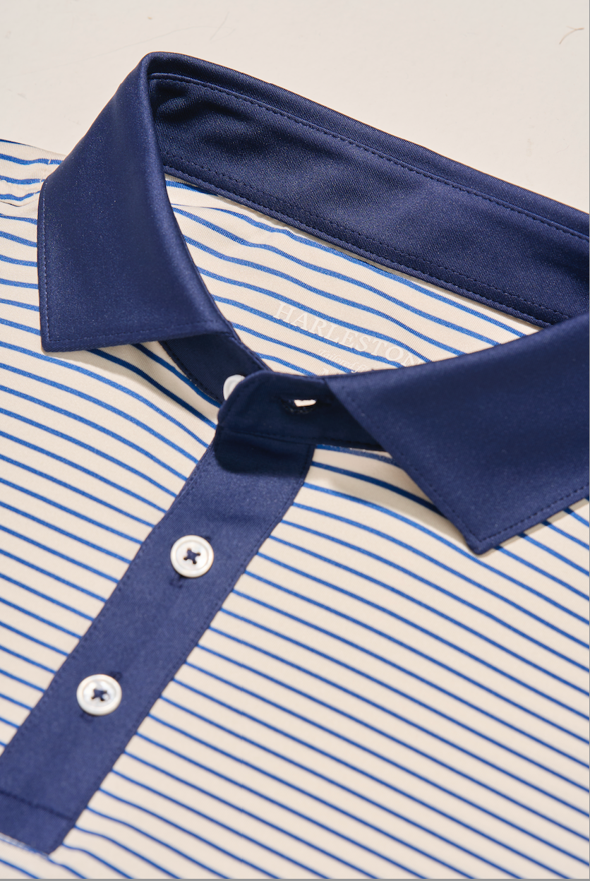 Close-up of a polo shirt by harlestons exhibiting the collar and the pearl buttons.